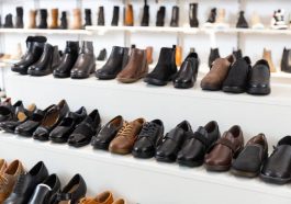 Diversity of leather and textile boots on shelves in salesroom of shoeshop.