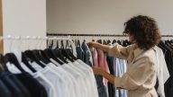woman in beige long sleeve choosing clothes from other clothes